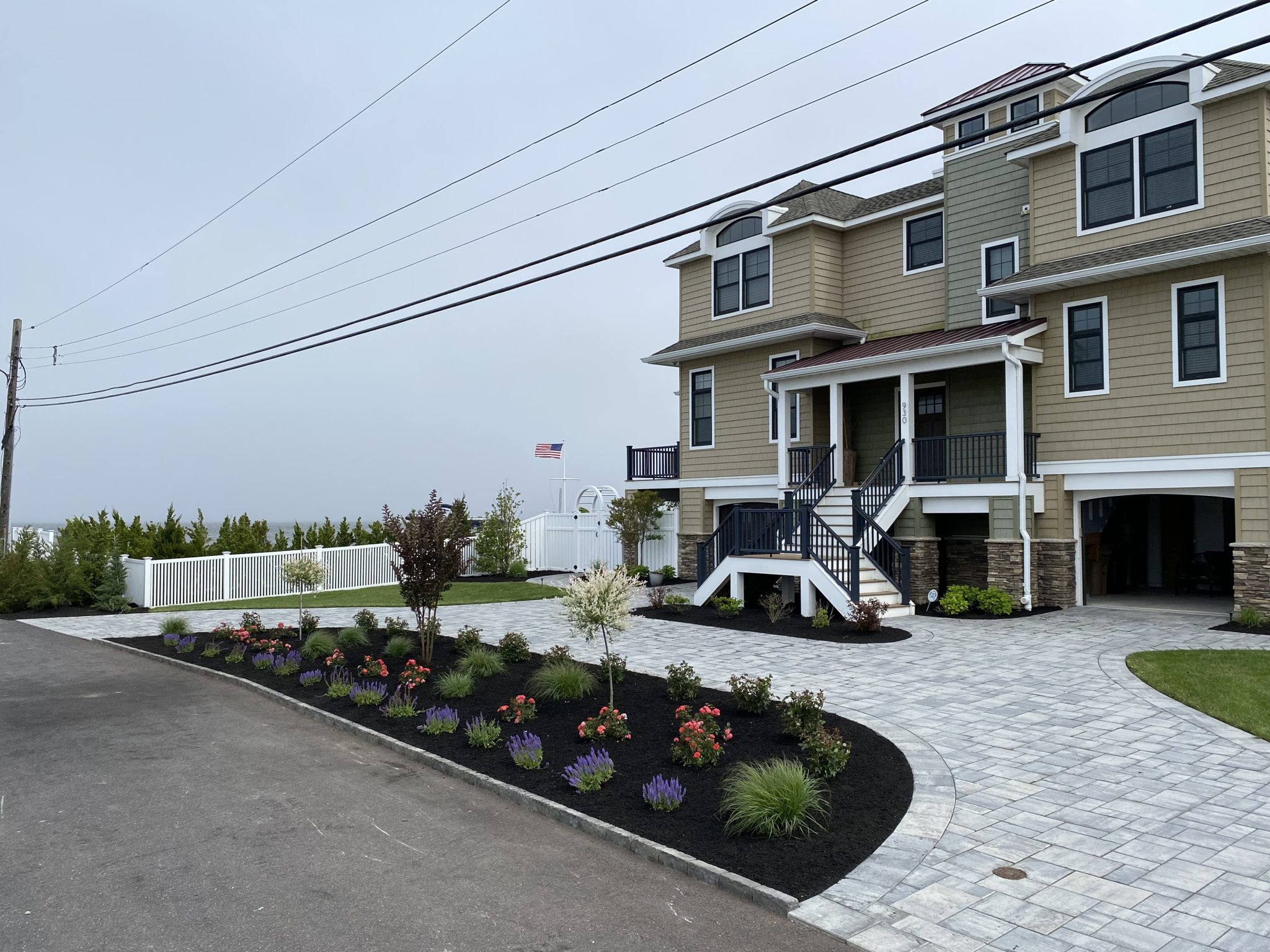 Front yard landscaping with shrubs and mulch by C&G Landscaping