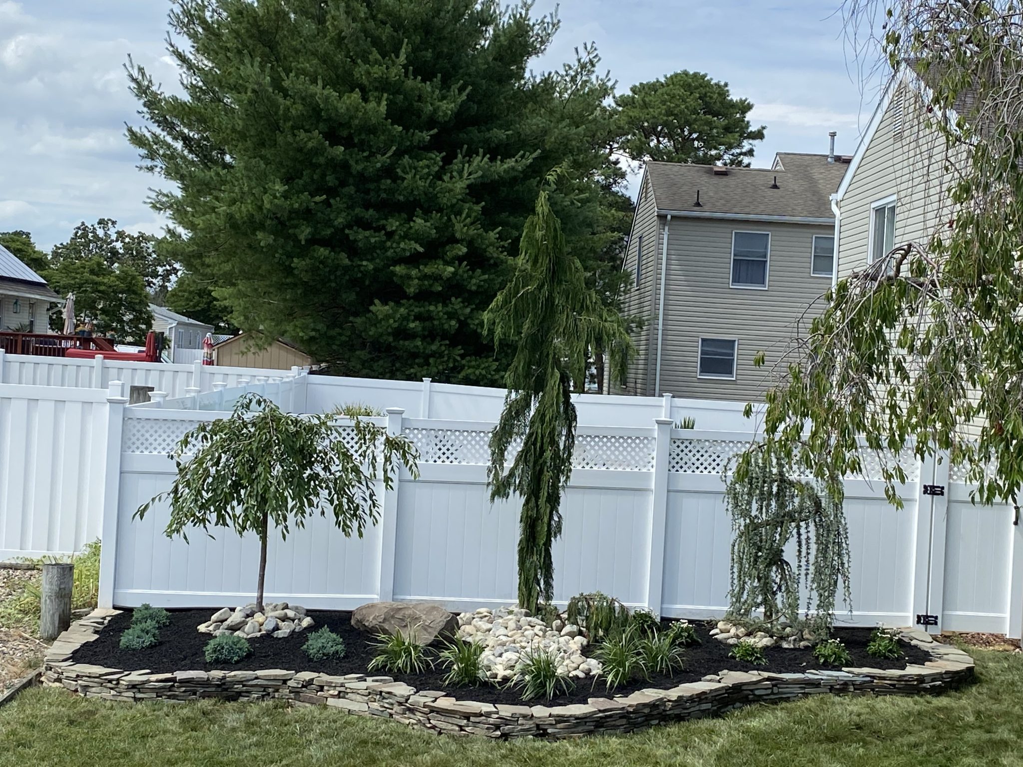 Front yard landscaping with shrubs and mulch by C&G Landscaping